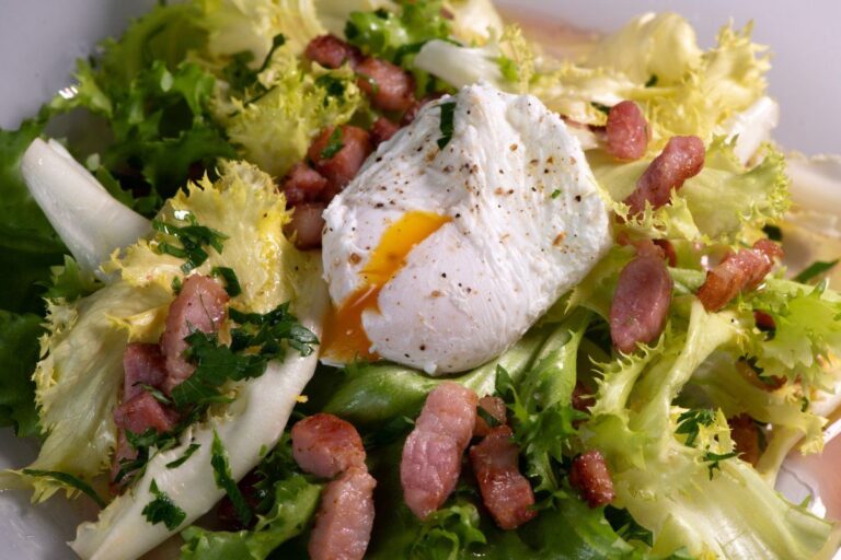 Salade frisée aux lardons et son œuf poché au jaune coulant.