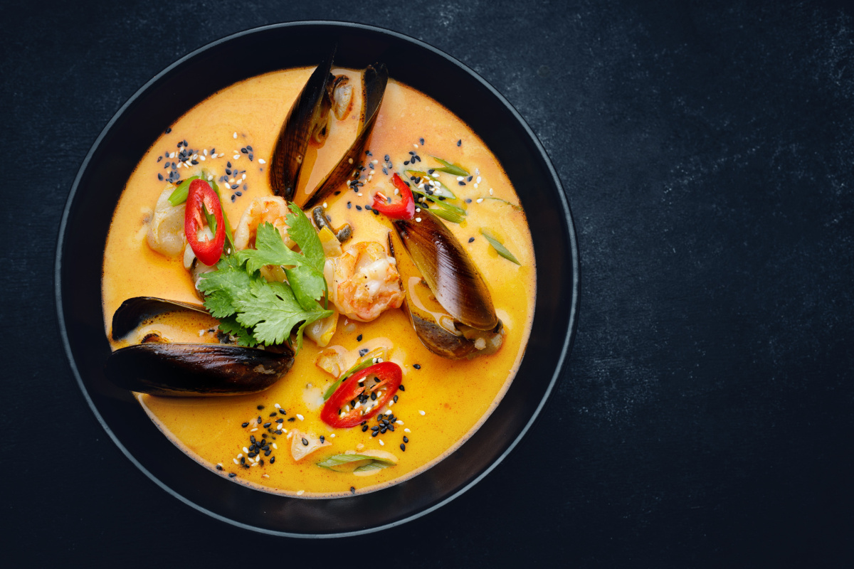 Soupe tha&iuml;landaise aux fruits de mer, garnie de piment, coriandre et s&eacute;same.